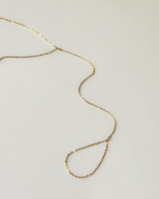 Gold plated thin dainty hand chain bracelet displayed on white background
