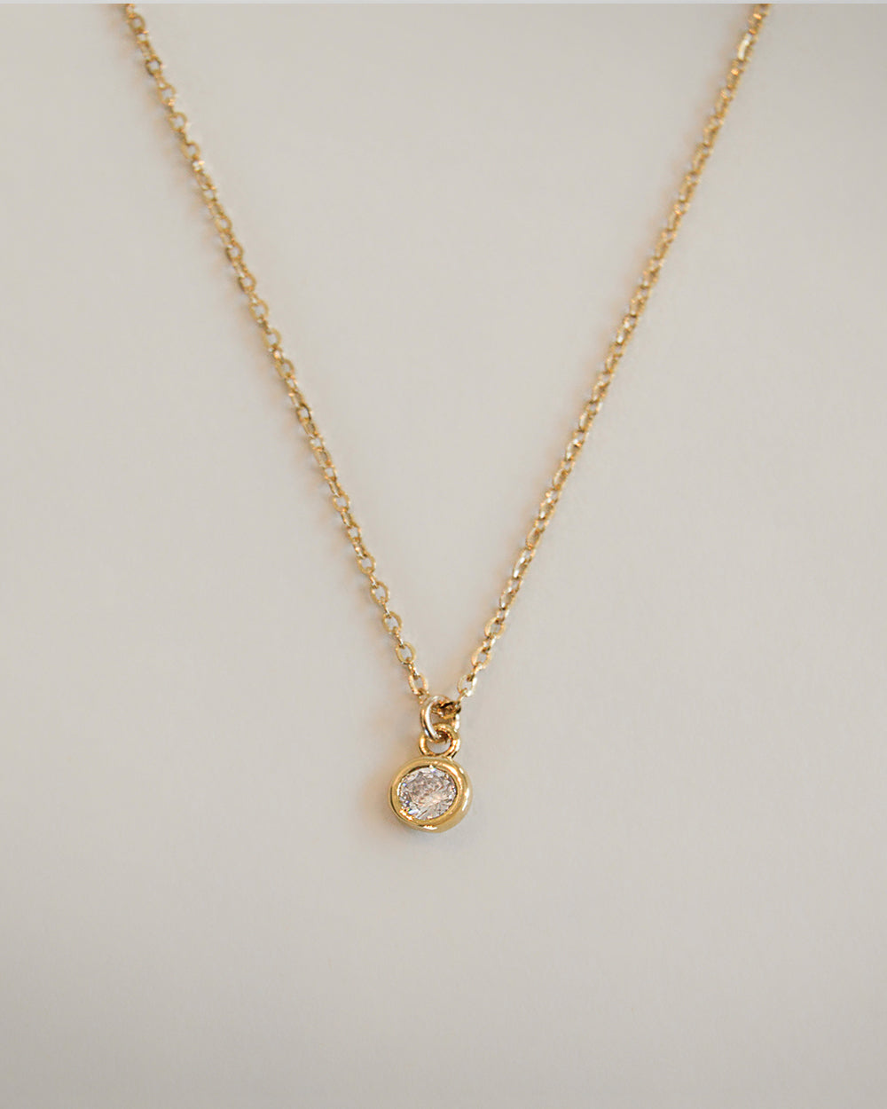 Gold plated necklace with round bezel charm close-up