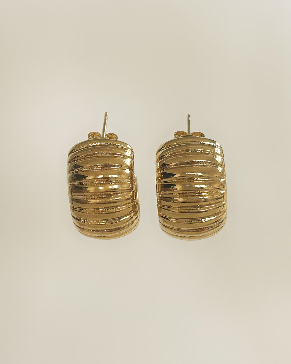 Stylish thick gold ribbed hoop earrings close-up