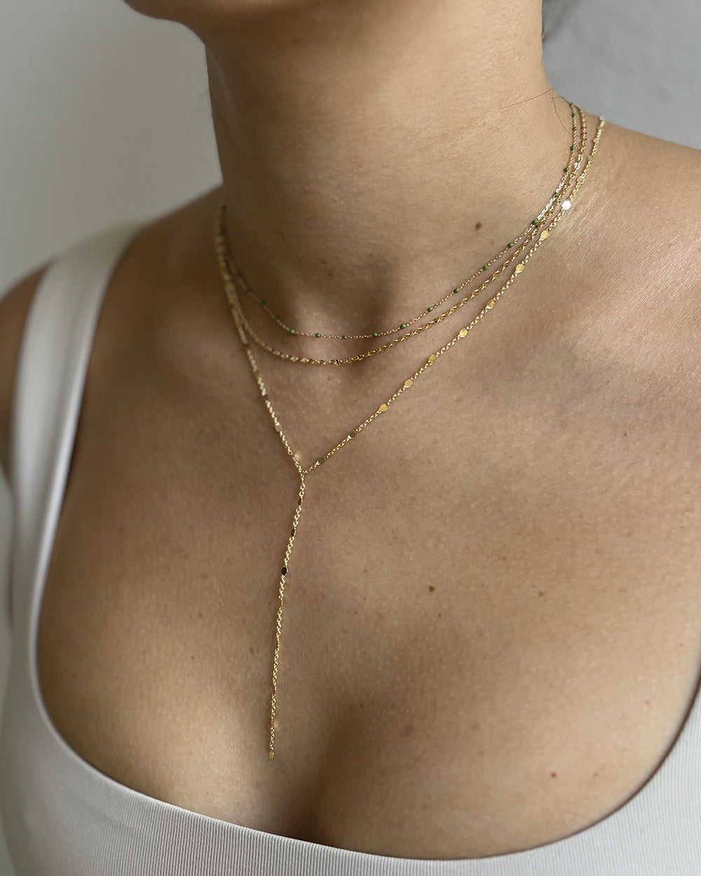 Model wearing dainty minimalist gold-filled necklace stack