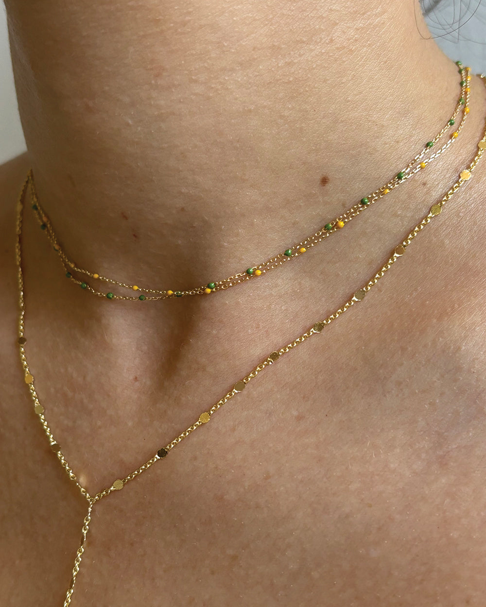 Close up of model wearing dainty necklaces