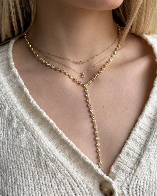 Model wearing 14K gold vermeil statement lariat necklace featuring a chain of sparkling stones