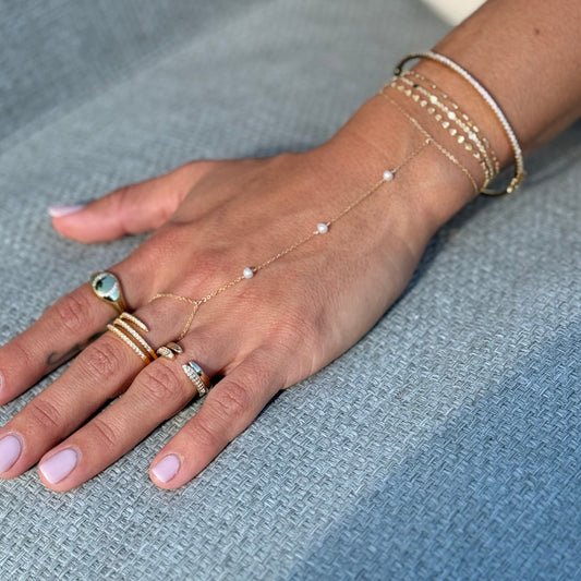 Gold filled stackable ring with pavé CZ detailing and one with a polished band on model hand