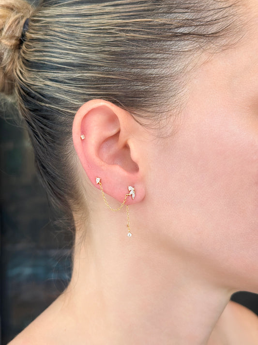 Model wearing 14K gold-coated sterling silver single earring featuring two linked piercings with front and back chain details