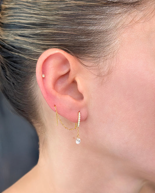 Gold plated threader earrings on model. Threaded through two piercings.